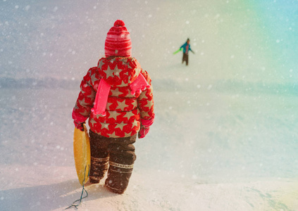 孩子冬天乐趣小女孩和男孩滑动在雪