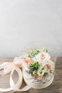 带鲜花的礼物。在塑料花瓶里混合花的花束。站在木板上