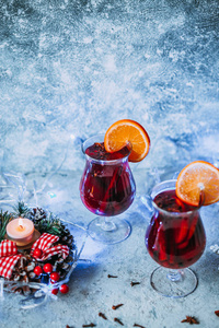 圣诞热的香料, 蜡烛和传统的新年装饰和橙色的灯光背景下的葡萄酒