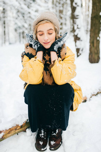 在白雪皑皑的冬天森林里躺在树上的奇怪的奇怪的女性。美丽的年轻可爱的女孩在户外放松。不寻常的女人在度假休息的性质。孤独的女士在严寒