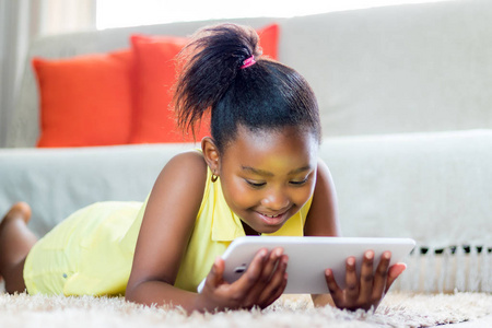 小非洲女孩在客厅里玩平板电脑