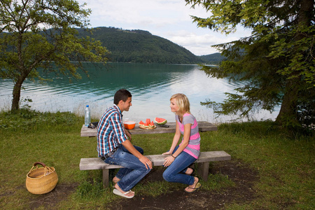 在湖边野餐的年轻夫妇