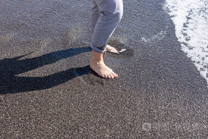 裸脚的妇女在黑海滩的水照片-正版商用图片0zsmw3-摄图新视界