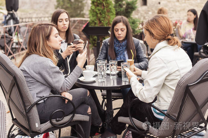 四妇女在咖啡馆使用应用智能手机玩社交网络照片-正版商用图片0zsr69-