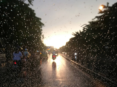 模糊的雨滴与街景汽车挡风玻璃在前夕