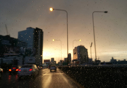 模糊的雨滴与街景汽车挡风玻璃在前夕