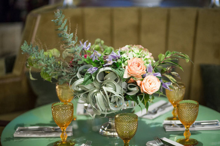 餐桌上的午餐 餐具, 玻璃杯和一束花在一个金属花瓶的腿
