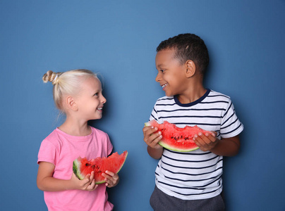 逗人喜爱的孩子吃西瓜在颜色背景