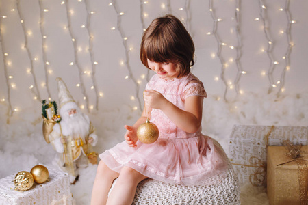 白色白种女孩的画像与蓝色眼睛坐与玩具庆祝圣诞节或新年假日