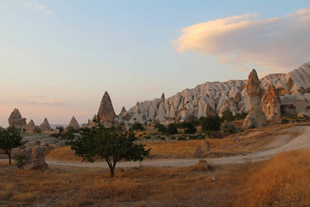 自然谷与火山凝灰岩石岩石在格雷梅在土耳其, 在日落
