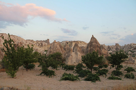 自然谷与火山凝灰岩石岩石在格雷梅在土耳其, 在日落