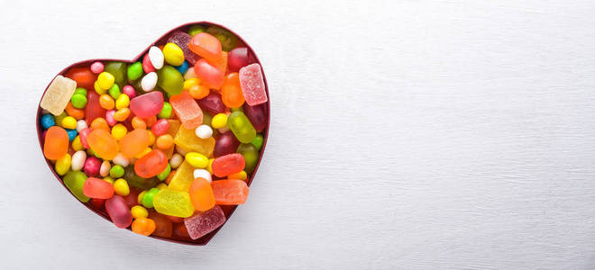 彩色糖果, 糖果和棒糖。在一个白色的木制背景。顶部视图。自由空间