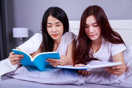 两个女人在卧室的床上看书