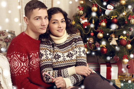 幸福的情侣在圣诞节装饰在家里。新年前夕, ornated 枞树。寒假与爱情观