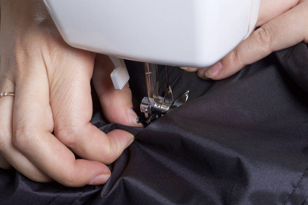 胜家缝纫机由个人企业家缝制衣服.一个女人正在缝制缝纫机.