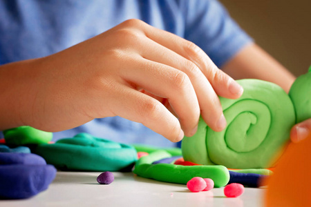孩子手用建模粘土或橡皮泥制作玩具图