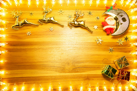 金黄木头背景的圣诞节灯框架与拷贝空间