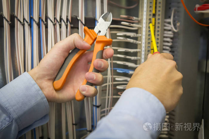 电气安装工作.电柜背景下电工手用螺丝刀和钳子