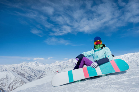 女孩坐在雪地上的滑雪板板。冬天.的