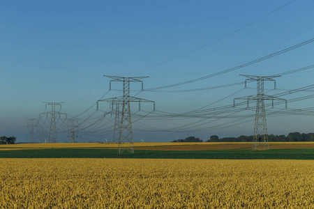法国诺曼底农业领域的高压电力线和输电塔。发电和配电。电力工业自然和农业理念