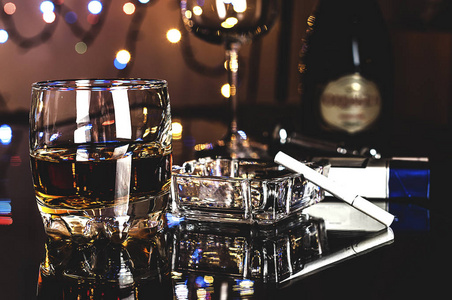 桌上有一杯威士忌和一个水晶烟灰缸照片