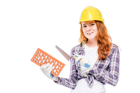 女孩在一个黄色的硬帽与砖建筑建设者
