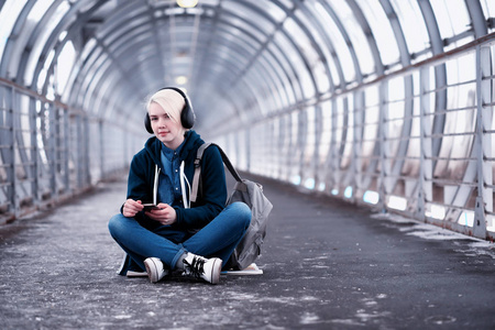 在地铁里大耳机听音乐的年轻学生