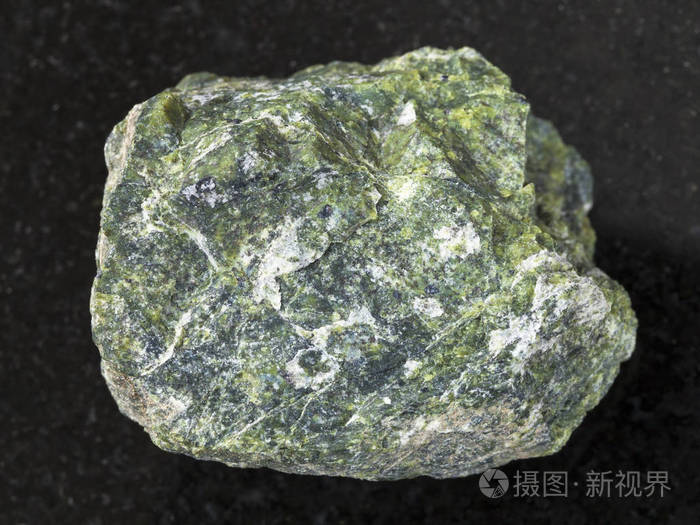 原始的蛇纹石石头在黑暗的背景