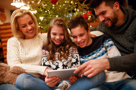 微笑的家庭有乐趣在数字式片剂为圣诞节