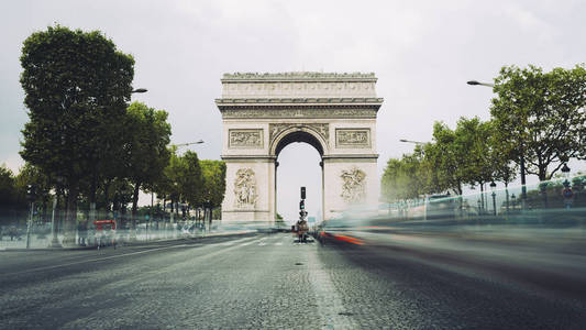 著名的香榭丽舍大街和凯旋门, 象征着光荣和历史遗产。法国巴黎标志性的旅游建筑地标。旅游和旅游概念。长时间曝光
