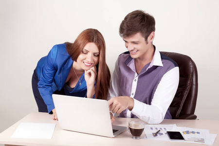业务办公室伏案工作的人，一个女人正在使用一台笔记本电脑和她的长官看电脑屏幕