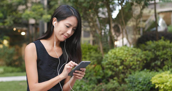 女人在公园里听手机音乐