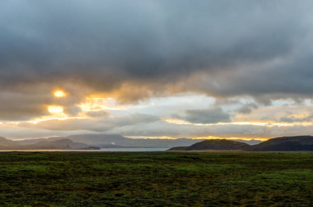 日落在冰岛风景与绿色青苔在金黄小时期间