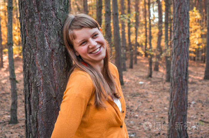 秋天妇女在秋天公园在树附近