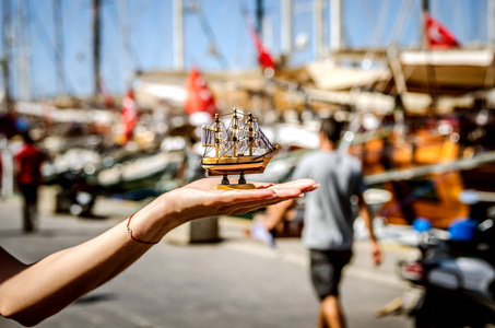 一个小纪念品船在大船背景下博德鲁姆堤在游人的手
