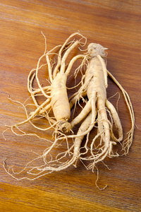 根木头韩国新鲜人参在木头背景照片