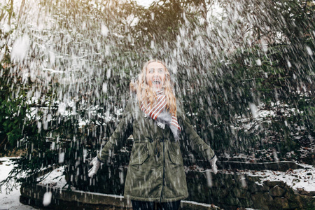 妇女投掷雪在空气