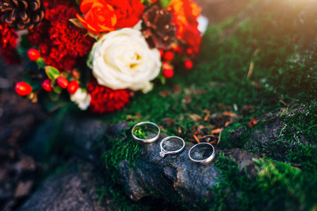 结婚戒指的背景木材与花束红色。 爱的概念