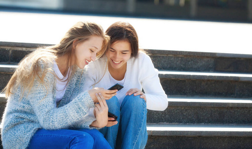 两个快乐的女青年在街上一起聊天
