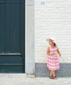 小女孩在粉红色的礼服和白色的夏季帽子户外