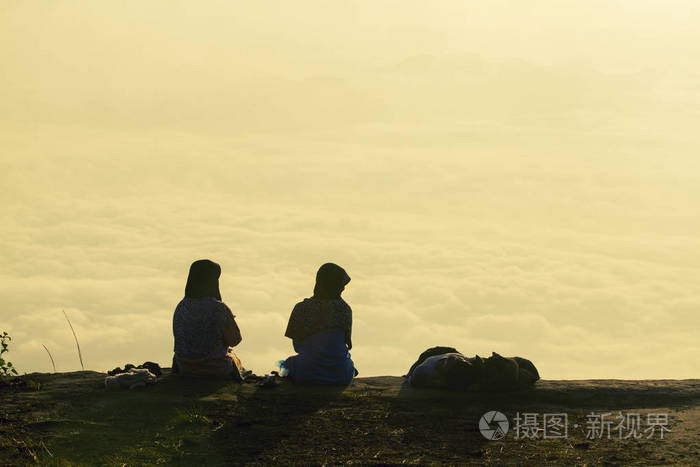 浪漫的情侣坐在山上看日出