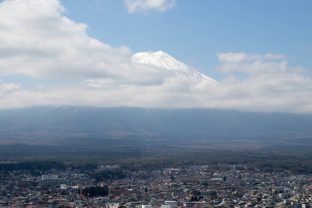 富士山是日本著名的地标，白云在蔚蓝的天空背景上