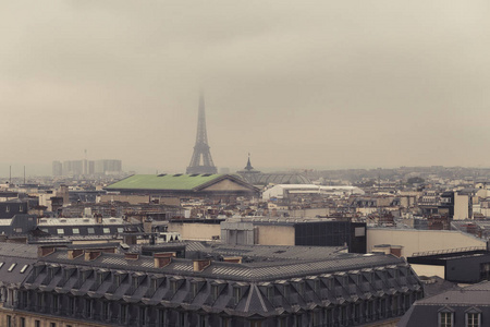 巴黎地平线上有屋顶和埃菲尔铁塔在雾天。巴黎标志和标志性地标。著名的旅游景点和浪漫的旅游目的地在欧洲。旅游理念