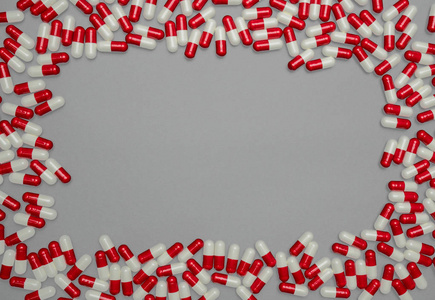红色, 白色的抗生素胶囊药片在灰色背景与拷贝空间。耐药性抗菌药物使用合理卫生政策和健康保险理念