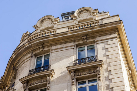 巴黎, 法国, 在2017年10月27日。太阳照亮城市街道和典型的建筑细节在市中心的房子。建筑立面片段, 典型的巴黎阁楼
