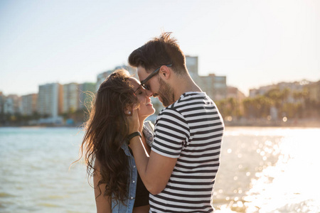 年轻快乐的情侣在海边抚摸着他们的鼻子