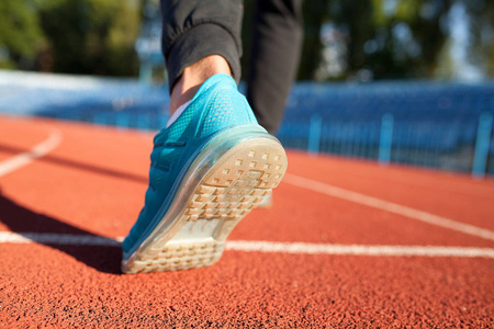 运动员跑脚跑在路上,特写在鞋上. 男子健身慢跑锻炼健康的概念.