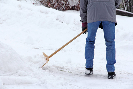 一个冬天的男人从街上清除积雪图片