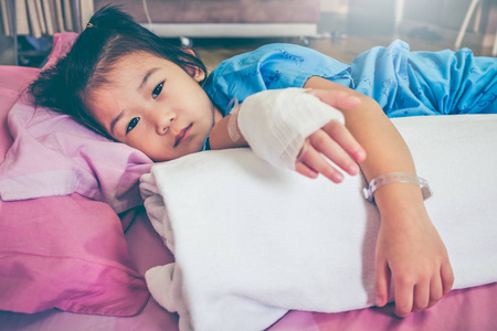 患病亚洲儿童入院时用生理盐水静脉注射 (iv) 滴在手上照片