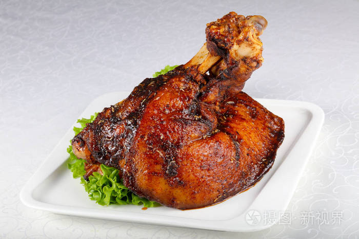 烤猪肉腿放在白色盘子里